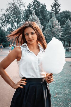 Young attractive brunette dressed skirt and blouse in Moscow summer parkの写真素材
