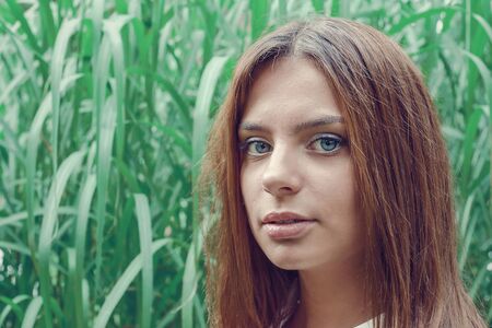 Young attractive brunette dressed skirt and blouse in Moscow summer parkの写真素材