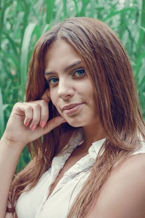 Young attractive brunette dressed skirt and blouse in Moscow summer parkの写真素材