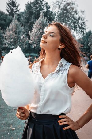 Young attractive brunette dressed skirt and blouse in Moscow summer parkの写真素材