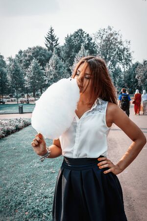 Young attractive brunette dressed skirt and blouse in Moscow summer parkの写真素材