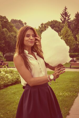 Young attractive brunette dressed skirt and blouse in Moscow summer parkの写真素材