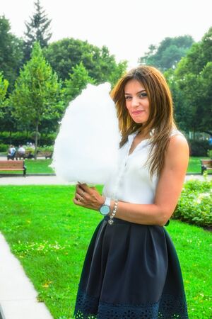 Young attractive brunette dressed skirt and blouse in Moscow summer parkの写真素材