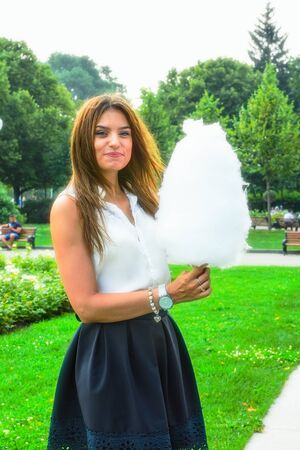 Young attractive brunette dressed skirt and blouse in Moscow summer parkの写真素材
