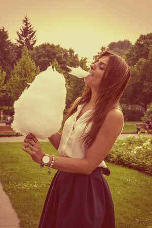 Young attractive brunette dressed skirt and blouse in Moscow summer parkの写真素材