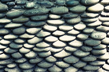 Stone wall of pebbles with concrete in garden backgroundの写真素材