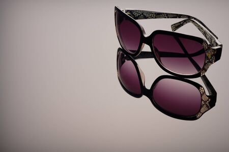 Sunglasses using soft focus on a black glass surface, with a gradient of light, reflexes and reflections, copy spaceの写真素材