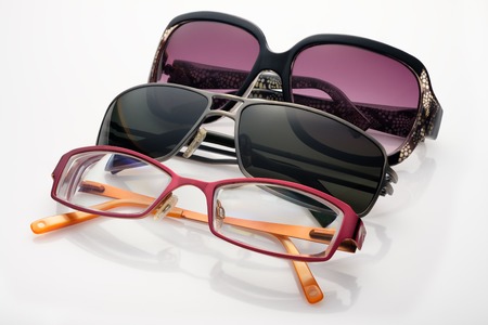 Three sunglasses and optical glasses on white backgroundの写真素材