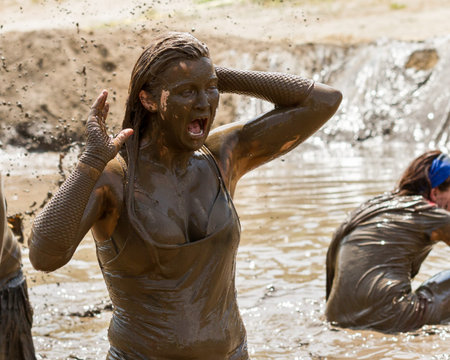 BOISE, IDAHO/USA - AUGUST 11, 2013: Unidentified woman screams as she is covered in mud at the dirty...