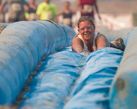 BOISE, IDAHO/USA - AUGUST: Unidentified woman slides face first down the slide at the The Dirty Dash in Boise, Idaho on August , 2013 のeditorial素材