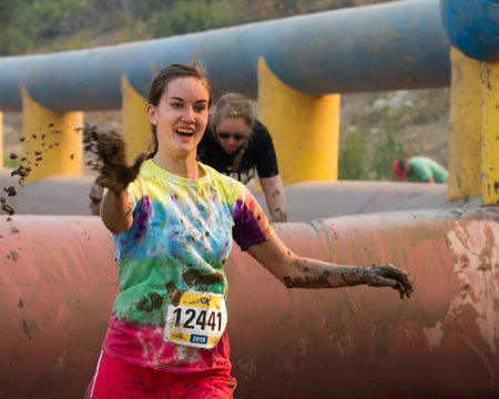 BOISE, IDAHO/USA - AUGUST: Unidentified woman throws some mud at the The Dirty Dash in Boise, Idaho...
