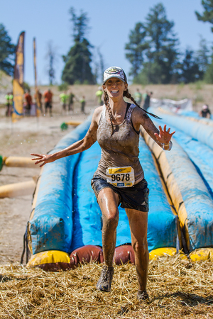 BOISE, IDAHO/USA - AUGUST 10, 2013: Runner 9678 just passed the slide and now runs to the mud pit at the The Dirty Dashのeditorial素材