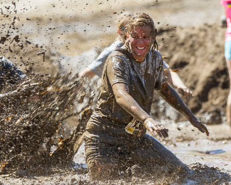 BOISE, IDAHO/USA - AUGUST 10, 2013: Runner 7358 tries to get away from someone making a big splash at the The Dirty Dashのeditorial素材