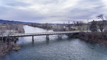 drone shot of a bridge going over water during the winter timeの写真素材