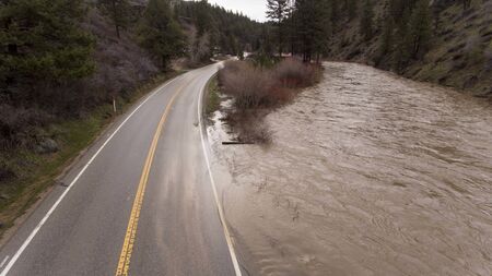flooded river spreading into the streets as shot from a droneの写真素材