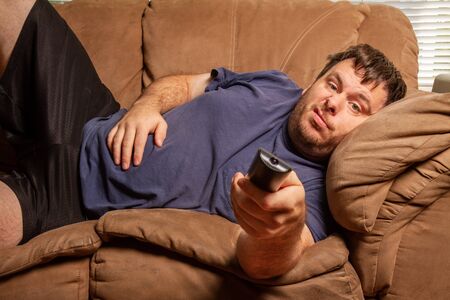 while watching TV this man does not look happyの写真素材