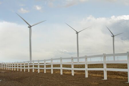 Fence that surrounds a wind farm while it creates powerの写真素材