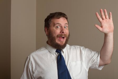 man waving hello at you with a big smileの写真素材