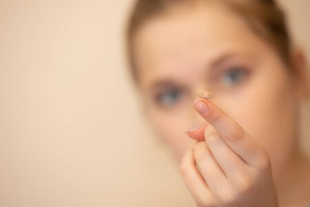Girl holds out a contact on her fingerの写真素材