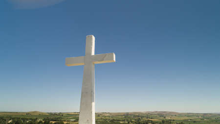 White cross on the top of a hillの写真素材