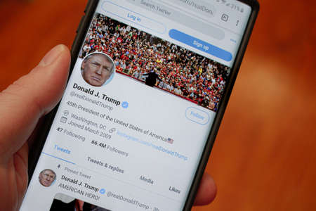 Trumps twitter page on a phone held by a handのeditorial素材