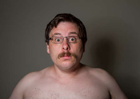 scared naked man wearing glassesの写真素材