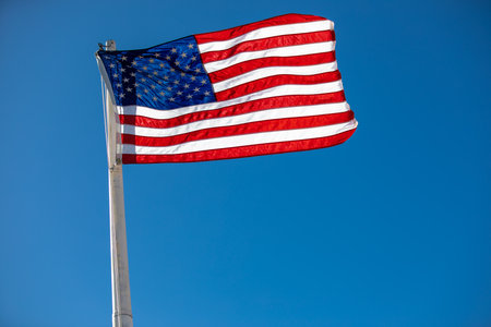 american flag waving in the wind being backlit by the sunの写真素材