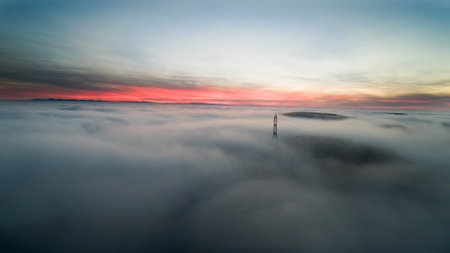 Misty Sunrise Above Power Line and Foggy Landscapeの写真素材