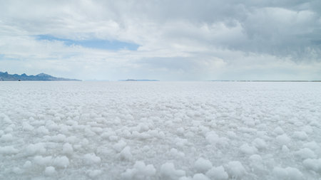 Vast White Salt Flats Under Overcast Sky with Horizonの写真素材