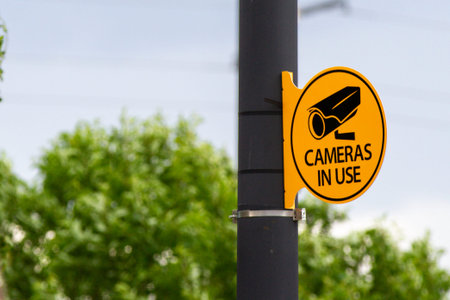 A pole with a sign on it that says Cameras in use