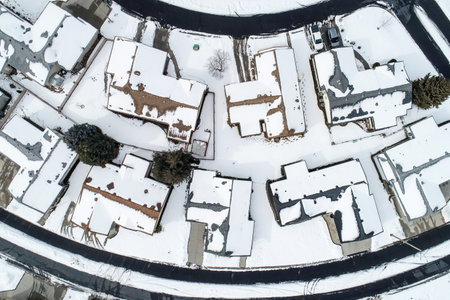 A snow covered neighborhood with houses and a streetの写真素材