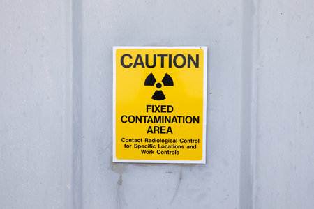 A yellow sign with black writing that says "Caution"の写真素材