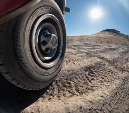 A tire is shown in the foreground of a desert landscapeの写真素材
