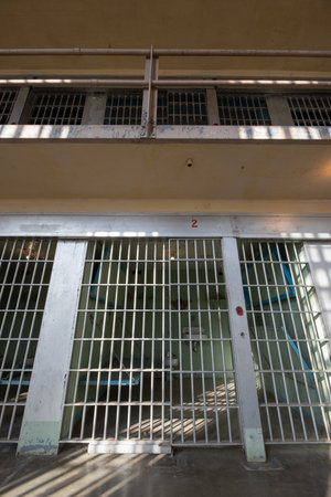 A prison cell with a barred window and a barred doorの写真素材