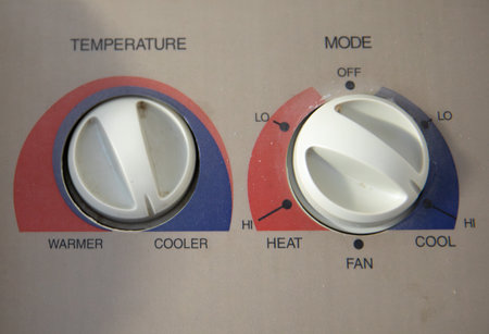 A white thermostat with a red and blue knobの写真素材