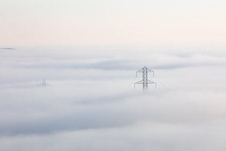 A power line tower is visible in the fogの写真素材