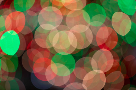 A blurry image of Christmas lights with green, red, and white colorsの写真素材