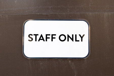 A sign that says "staff only" is on a wallの写真素材