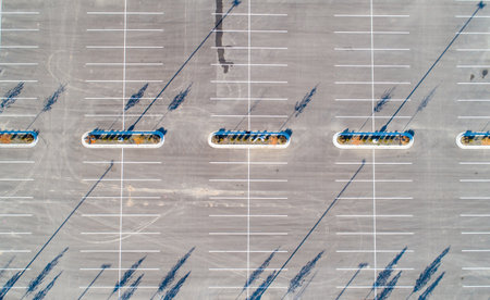 A parking lot with empty parking spaces and a few treesの写真素材