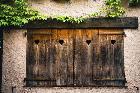 Old vintage wooden and rustic window with hearts in a vintage villageの写真素材
