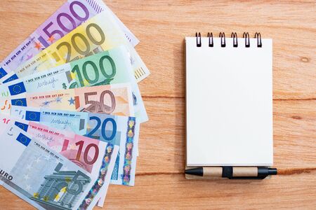 background with euro banknotes with different values and notepadの写真素材