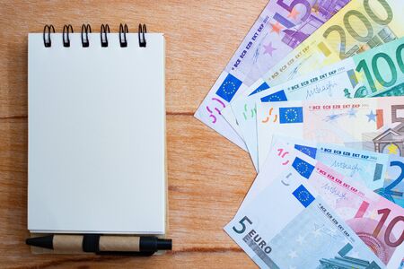 background with euro banknotes with different values and notepadの写真素材