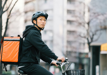 A food delivery worker navigating city streetsの素材