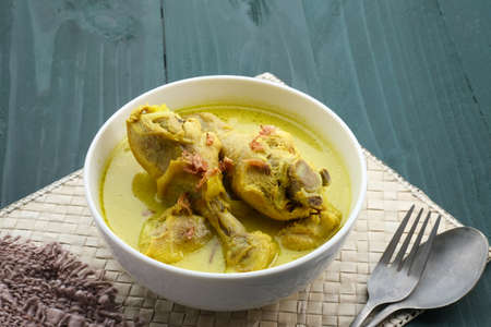 Opor Ayam, Indonesian traditional  food in white bowl. Opor made from chicken cooked with coconut milk and spices. Its served to celebrate Eid Adha and Eid Fitr.の写真素材
