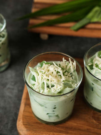 Buko Pandan, a dessert from Philippines, made from jelly, young coconut, evaporated milk, sweetened condensed milk, and ice. Served on glass with cheese topping.の写真素材