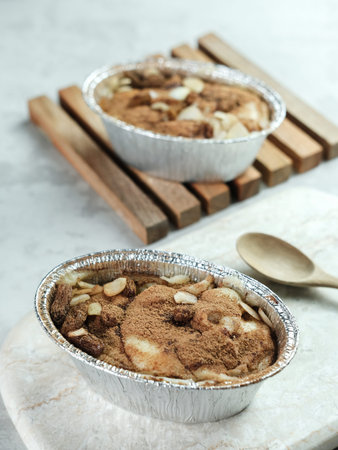 Klappertaart is one of indonesian traditional dessert, from Manado. Bread klappertaart with raisin and almond topping, dusted with cinnamon powder, Dutch influenced dessert.の写真素材