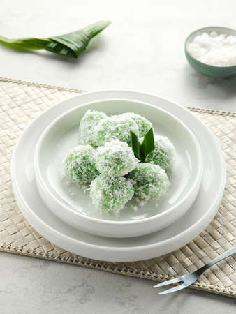 Klepon is Indonesian popular traditional snack, made from glutinous rice flour which is formed into small balls and filled with brown sugar. Finally covered with grated coconut.の写真素材