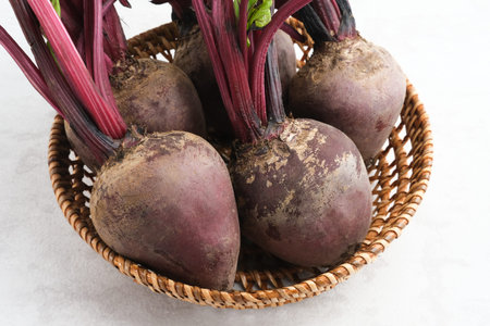 Fresh organic beets, beetroot in rattan basket on a white background. This fruit is usually made in...