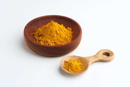 Turmeric powder or Kunyit bubuk, served in wooden bowl, copy space.の写真素材