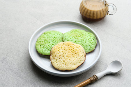 Serabi or Surabi,  Indonesian pancake made of flour, rice flour and coconut milk. Served with palm sugar sauce. Sweet and savory.の写真素材